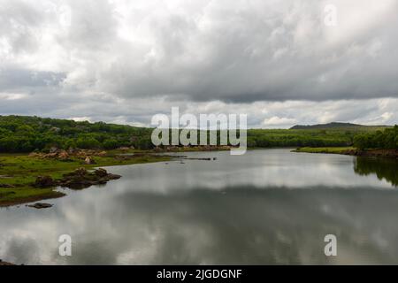 Regen füllte Monsunwolken über einem See in der indischen Landschaft Stockfoto