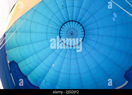 Heißluftballon von innen. Blauer Ballonstoff mit Seilen. Einen Moment vor einem Flug, wenn Sie nach oben schauen. Stockfoto