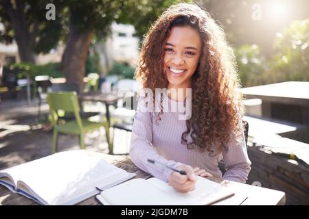 Eine Studentin, die sich um ihr Studium kümmert. Eine junge Studentin, die in einem Café studiert. Stockfoto