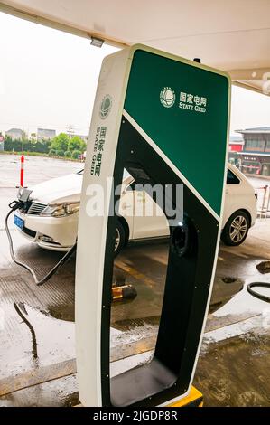 Einen Denza Elektroauto aufgeladen von einem State Grid-schnell-Ladegerät an der Chang'an Tankstelle in abgesperrten Bereich verlassen Stockfoto