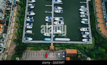 Eine Luftaufnahme von weißen Booten auf dem Wasser in einem Hafen in einer kleinen Stadt Stockfoto