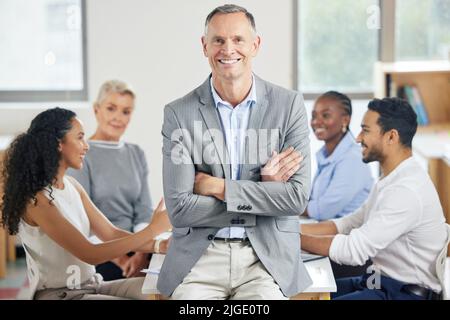 Mein Team zur Größe führen. Ein leitender Geschäftsmann während eines Mitarbeitertreffens. Stockfoto