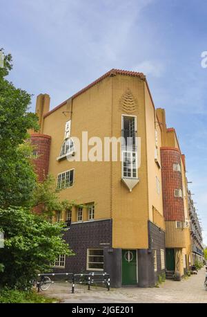 Amsterdam, Niederlande. Juni 2022. Details und Fassaden der charakteristischen Backsteinkonstruktion des Wohngebäudes in Amsterdam Schule Stil architec Stockfoto