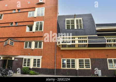 Amsterdam, Niederlande. Juni 2022. Details und Fassaden der charakteristischen Backsteinkonstruktion des Wohngebäudes in Amsterdam Schule Stil architec Stockfoto