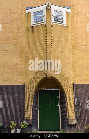 Amsterdam, Niederlande. Juni 2022. Details und Fassaden der charakteristischen Backsteinkonstruktion des Wohngebäudes in Amsterdam Schule Stil architec Stockfoto