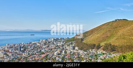 Panoramabild einer Küstenstadt am Fuße eines Hügels. Das zentrale Geschäftsviertel von Kapstadt, Südafrika, Ein malerischer Horizont, der beides zeigt Stockfoto