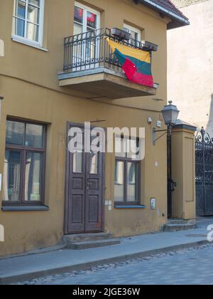 Zarzecze, Vilnius, Litauen - 2018. April: Die litauische Flagge hängt auf dem Balkon eines alten Mietshauses in der Užupis-Straße. Osteuropa Stockfoto