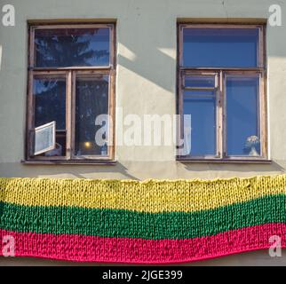 Vilnius, Litauen - 2018. April: Die litauische Flagge hängt auf dem Balkon der alten Wohnungen in Vilnius. Osteuropa Stockfoto