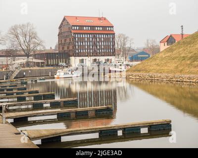 Klaipeda, Litauen - April, 2018: Boote auf dem Fluss Danė. Im Hintergrund das Old Mill Hotel. Dane River, Osteuropa. Stockfoto