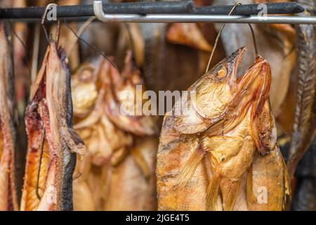 Hängen rauchgetrocknete verschiedene Fische in einem Fischmarkt nur mit Hartholz-Hackschnitzel in einem Raucher geraucht und bereit zu essen Stockfoto