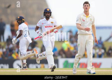 Galle, Sri Lanka. 10.. Juli 2022. Der Australier Mitchell Swepson (R) beobachtet den Ball, während die Sri-lankischen Dinesh Chandimal (C) und Kamindu Mendis (L) während des 3.-tägigen Test-Cricket-Spiels 2. zwischen Sri Lanka und Australien im Galle International Cricket Stadium in Galle am 10.. Juli 2022 zwischen den Wickets laufen. Viraj Kothalwala/Alamy Live News Stockfoto