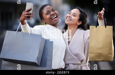 Nun werden beste Freunde für immer. Zwei Freunde nehmen Selfies beim Einkaufen zusammen. Stockfoto