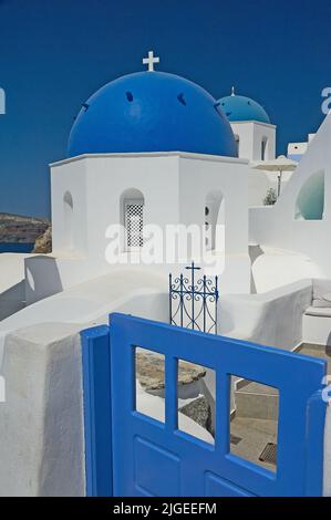 Traditionelle griechisch-orthodoxe Kirchen mit blauer Kuppel in Oia oder Ia auf der Insel Santorini, die zu den Kykladen-Inseln vor dem griechischen Festland gehört Stockfoto