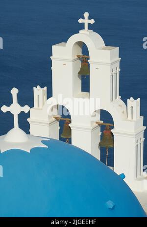 Santorini, Griechenland und die blaue Kuppel und der Glockenturm der griechisch-orthodoxen Kirche, die gemeinhin als die drei Glocken von Thira (Fira) bekannt ist Stockfoto