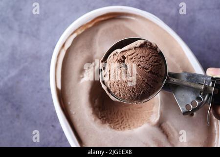 Pflücken Sie Eis mit einem Löffel aus einer Schüssel Stockfoto