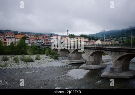 Borgo Val di Taro, Italien - Mai 2022: Panoramablick auf die Stadt Borgotaro bei Regen. Brücke über den Fluss Taro, Stadtbild des italienischen Dorfes Stockfoto