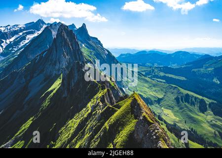 Wanderer ruht an einem schönen Ort mit einem atemberaubenden Blick auf das Säntis-Massiv Stockfoto