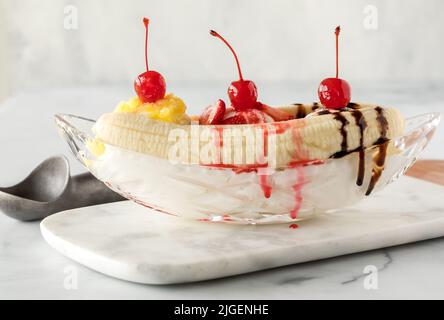 Cremige und köstliche Banane, die auf einer Marmorplatte gespalten ist und zum Essen bereit ist. Stockfoto