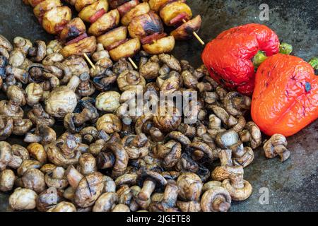 Köstliche Grillmahlzeit auf der Bratpfe. Paprika, Pilze, Kartoffeln, Kebab. Essen für Picknick Stockfoto