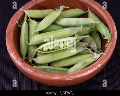 Grüne Erbsen in einer Holzschüssel. Nahaufnahme. Stockfoto