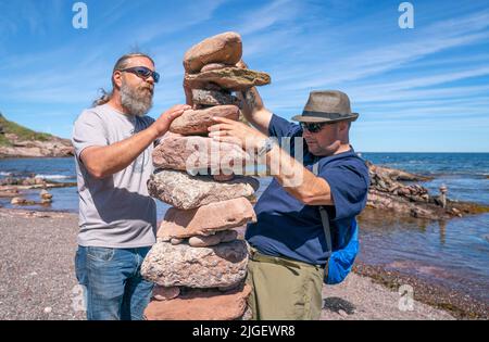 Die Teilnehmer nehmen an den European Stone Stacking Championships 2022 am Eye Cave Beach in Dunbar, East Lothian, Teil. Die Meisterschaften sind Europas größter Wettbewerb für alle Liebhaber und Künstler des Steinstapelns und des Felsausgleichs. Bilddatum: Sonntag, 10. Juli 2022. Stockfoto