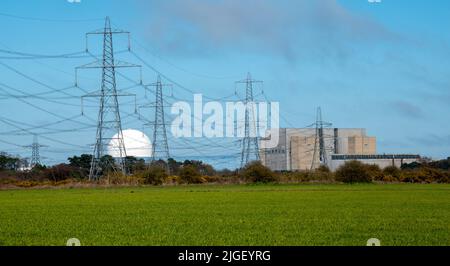 Sizewell Kernkraftwerke in weiter Ferne mit grünen Feldern im Vordergrund mit vielen Stromleitungen Stockfoto