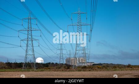 Sizewell Kernkraftwerke in weiter Ferne mit grünen Feldern im Vordergrund mit vielen Stromleitungen Stockfoto