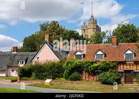 Suffolk, Großbritannien - August 11. 2021: Der malerische Blick auf die Kirche St. Mary the Virgin und die Cottages im Dorf Cavendish in Suffolk, Großbritannien. Stockfoto