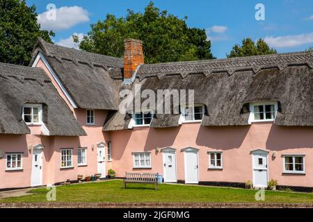 Suffolk, Großbritannien - August 11. 2021: Wunderschöne pinke Cottages im Dorf Cavendish in Suffolk, Großbritannien. Stockfoto