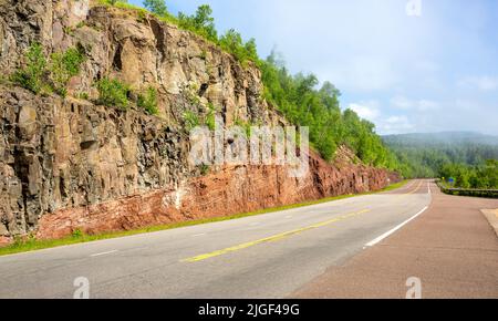 Querschnitt eines ausgegrabenen Berges und Gesteins, der vulkanische Schichten entlang der Nordküste des Lake Superior in Good Harbor Bay, Minnesota, zeigt Stockfoto