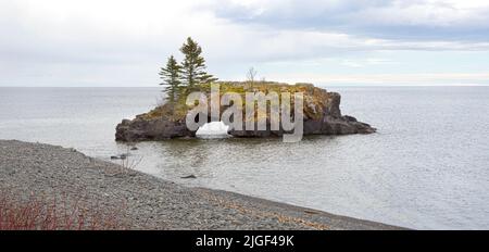 Insel und Landform bekannt als Hollow Rock in Lake Superior in der Nähe von Grand Portage, Minnesota. Zweimal im Jahr, für etwa eine Woche im November und eine Woche im Janu Stockfoto