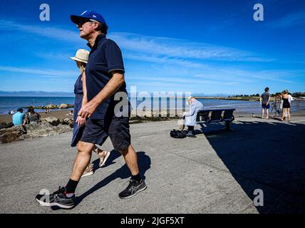 Ein Mann liest am Sonntag bei gutem Wetter am Seapoint Beach in South Dublin ein Buch von sich selbst, wie Eireann prognostizierte, dass die warmen und trockenen Tage mit den höchsten Temperaturen auf 25 Grad anstiegen. Bilddatum: Sonntag, 10. Juli 2022. Stockfoto