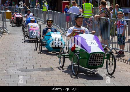 Ringwood, Hampshire, Großbritannien. 10.. Juli 2022. Der British Pedal Car Grand Prix fand erstmals 1987 in der Marktstadt Ringwood statt. Die Veranstaltung zieht nun jedes Jahr Tausende von Zuschauern an, um die „Autos“ beim Rennen um die Strecke in der Stadt zu beobachten - Menschenmengen strömen, um die Aufregung an einem heißen, sonnigen Tag zu sehen. Quelle: Carolyn Jenkins/Alamy Live News Stockfoto