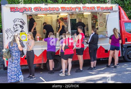 Fastfood-Van, der Burger und Pommes an junge Leute verkauft Stockfoto