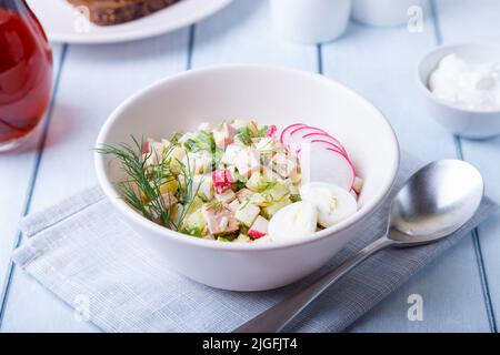 Okroshka mit Kvass und Wurst. Traditionelle klassische kalte russische Suppe. Nahaufnahme. Stockfoto