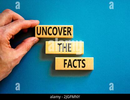 Entdecken Sie das Facts-Symbol. Concept Words enthüllen die Fakten auf Holzblöcken auf einem wunderschönen blauen Hintergrund. Geschäftsmann Hand. Business und U Stockfoto