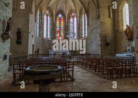 Die Kirche Mariä Himmelfahrt in Mourèze (Frankreich) gehört zu den mittelgroßen Gebäuden. Der Innenraum wirkt trotz seiner geringen Größe recht imposant. Der siebenstimmigen Chor mit einer fünfeckigen Apsis stammt aus dem 14.. JahrhundertDer siebenstimmigen Chor mit einer fünfeckigen Apsis stammt aus dem 14.. Jahrhundert. Die Kirche erstreckt sich bis zu der Felswand, in der sich das Schloss befand und war Teil des Befestigungsapparates des Dorfes Stockfoto