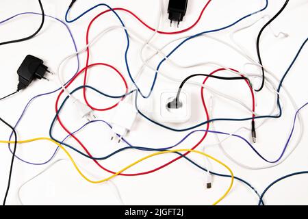 Viele bunte Kabel Kabel Kabel Kabel Kabel mit Steckern und Steckdose auf weißem Hintergrund Stockfoto