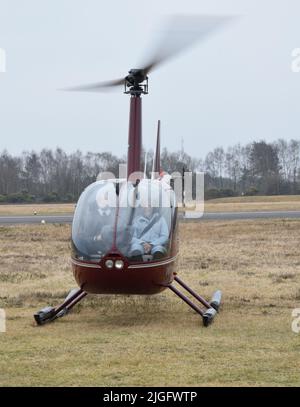 Reading, Vereinigtes Königreich - März 15 2015 - Ein Raven R44 Hubschrauber, Registrierung G-LHXL, der für Vergnügungsflüge am Blackbushe Airport vor dem Abflug eingesetzt wird Stockfoto