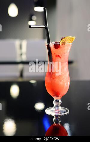 Frischer Cocktail mit Eis, Beeren und Limette auf dunklem Hintergrund Stockfoto
