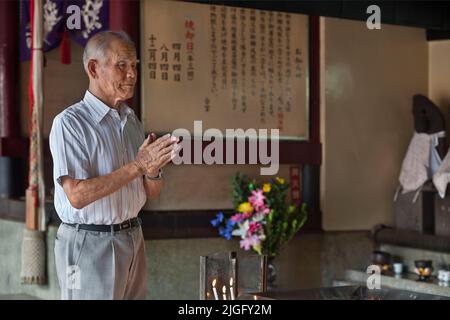 Älterer Mann betet am Schrein in Tosu, Kyushu, Japan Stockfoto