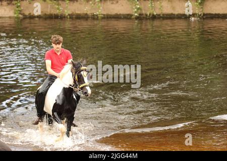 Ein junger Mann auf seinem Pferd im Fluss Eden, Appleby Horse Fair, Appleby in Westmorland, Cumbria Stockfoto