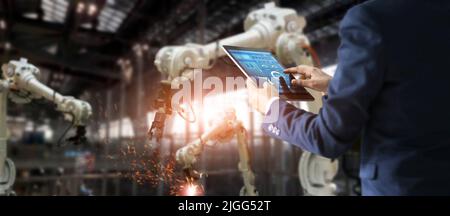 Ein Blick auf einen Wirtschaftsingenieur mit Tablet Check und Steuerung Automatisierung Roboterarm Maschine Stockfoto