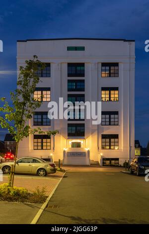 Das ikonische weiße Gebäude (Lilly Court) in der Abenddämmerung in Chapel Gate, ehemals die Eli Lilly Fabrik, mit klassischer Art-Deco-Architektur. Basingstoke, Großbritannien Stockfoto