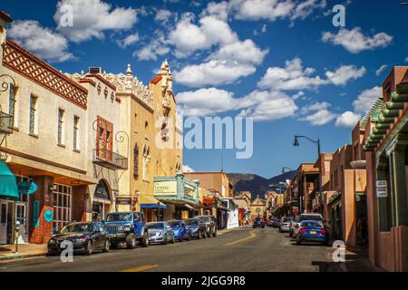 07-17-2017 Santa Fe New Mexico USA - Downtown Street mit ikonischer adobe Santa Fe Architektur und Autos auf beiden Seiten mit Bergen in Backgroun geparkt Stockfoto