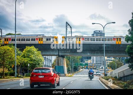 2014 12 04 Brisbane Australia - Rote Auto- und Motorradfahrt unter Überführung mit Zugfernschild zur Ausfahrt nach Gold Coast and City Stockfoto