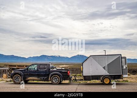 2021 05 21 in der Nähe von Taos New Mexico USA - Muddy 4-Wheel Drive Pickup Truck Schleppen Utility Trailer für Dirt Bikes geparkt am Rio Grande Gorge State Park Stockfoto