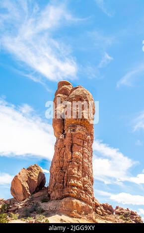 Der einflügelige, hoodoospießige Sandstein steht auf einem Hügel neben einem gefallenen Felsen vor blauem Himmel im Arches National Park, Utah, USA, Kopie. Stockfoto