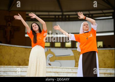 Freiwillige zeigen Hand- und Körperbewegungen für christliche Lieder beim Mladifest 2021, dem Jugendfestival in Medjugorje. Stockfoto