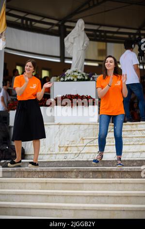 Freiwillige zeigen Hand- und Körperbewegungen für christliche Lieder beim Mladifest 2021, dem Jugendfestival in Medjugorje. Stockfoto